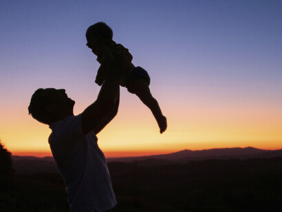 Un padre alza con felicidad a su pequeño
