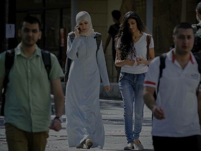 A Muslim Arab woman as an immigrant is wearing a hijab and walking down the western cobblestone streets
