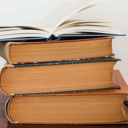 Pila di libri: "... forse dovremmo ricominciare da qui. Dai libri, dalle storie, dalle parole. Perché lì dentro, anche se spesso ce lo dimentichiamo, ci sono le mappe per non perderci"