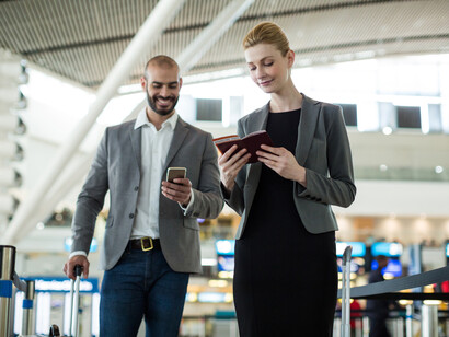 Businesspeople waiting in queue at a check-in counter with luggage