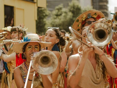 Bloco de rua. De cara se depara com o Cadu com a sua fantasia de camisa social e colete puffer. Compram umas cervejas no primeiro ambulante e vão em busca dos demais amigos, enquanto acompanham e ouvem o Bloco do Abrava


