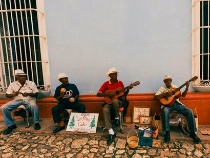 A group of elderly Cuban musicians plays traditional instruments on a cobbled street, capturing the island’s soulful sound that echoes the legacy of the Buena Vista Social Club
