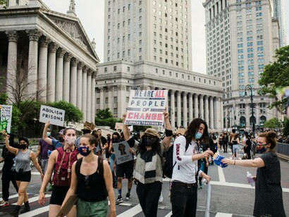 New York, United States. Demonstrators kneel in protest, holding signs in a public space