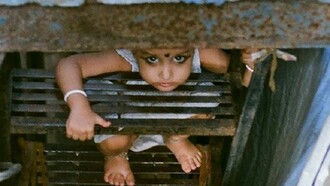 A child and his sad looking across a staircase