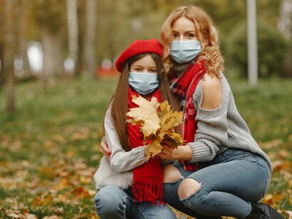 A mother insisting her daughter wears a masks even if it's at the park