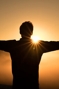 The essence of success with a stunning silhouette photo featuring a man on a cliff during a breathtaking sunset