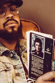 Homem lê biografia de Johnny Cash. Por meio da vida de uma pessoa, podemos vislumbrar os dilemas, os valores e as transformações de uma época. A biografia nos permite explorar o tecido da história de forma íntima, conectando eventos e contextos ao mundo concreto das escolhas e ações individuais