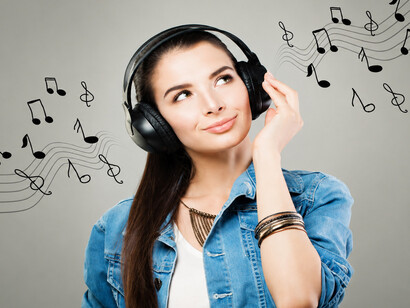 A smiling young woman immersed in music, reflecting the experience of a tune replaying repeatedly in the brain