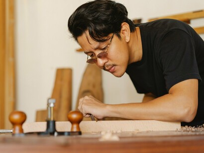 A craftsman meticulously shaping wood by hand, representing the precision and commitment required to execute a strategy successfully