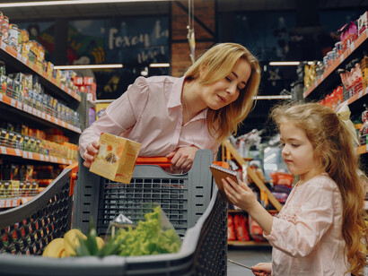 Family grocery shopping with a parent teaching a child to pay at the checkout