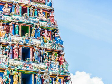 As figuras divinas esculpidas no templo parecem observar silenciosamente a cidade. No hinduísmo, o sagrado não habita apenas os céus, ele também caminha entre homens e animais