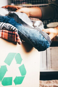 Mujer colocada su ropa usada en una caja de reciclaje para una 'segunda vida'