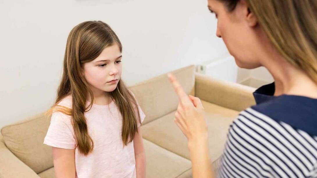 An upset mother raising her finger at her worried child trying to be a parent but probably coming off as an authoritarian