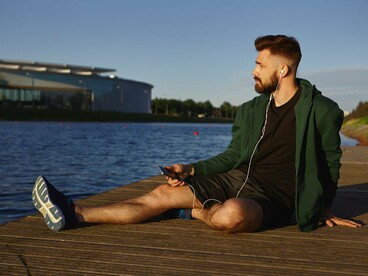 A man sitting by the waterfront, representing the value of stillness in a world that never stops