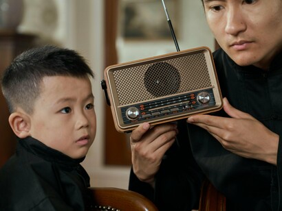Pai e filho escutam o rádio. Um grande avanço ocorreu em 1922, quando peças completas de teatro foram transmitidas numa estação de rádio toda a semana. Um programa com continuidade bem estabelecido estava sendo lançado, abrindo o precedente para as demais estações radiofônicas. Concorrentes começaram a transmitir pequenas sequências de peças no ar para atiçar o interesse do público e eventualmente programas escritos especialmente para o meio radiofônico foram sendo feitos