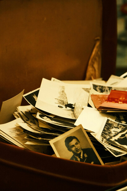 Old photographs displayed inside a vintage suitcase