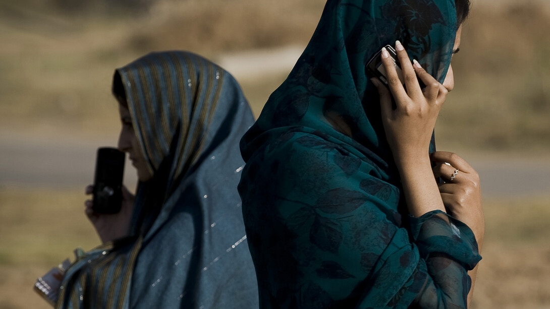 Mujeres afganas hablando con sus teléfonos móviles