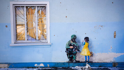 Grafiti en que una niña vestida con los colores de la bandera de Ucrania confronta a un soldado ruso