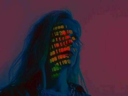 A woman with binary code on her face as she deals with the AI