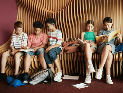 Un gruppo di bambine e bambini legge e si informa