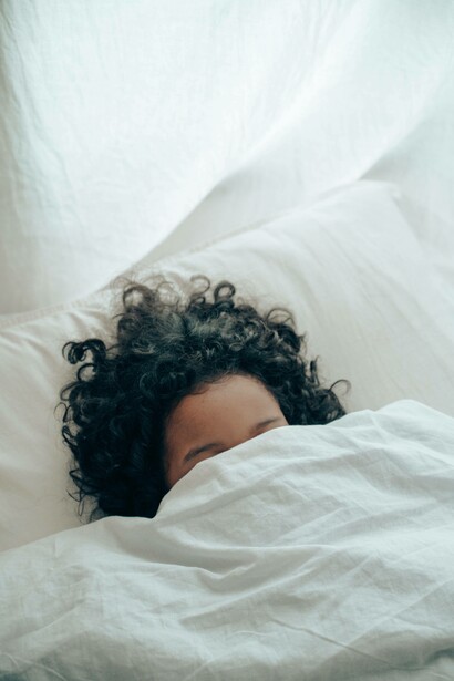 Woman sleeping with covers on her face