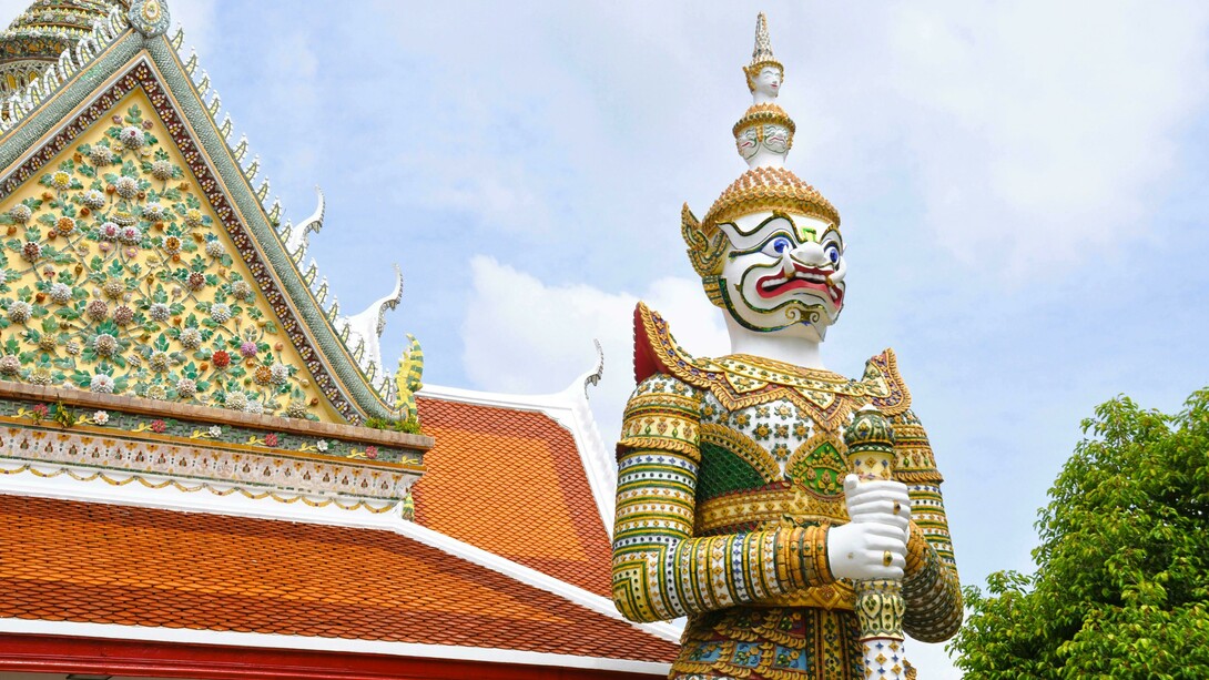 Yaksha and Yakshini sculptures at an Indian temple; giant guardian statue at a Thai Buddhist temple