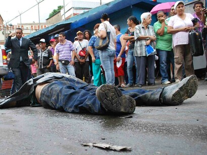 Los viandantes se agolpan alrededor de un cadáver en las calles de Caracas, Venezuela