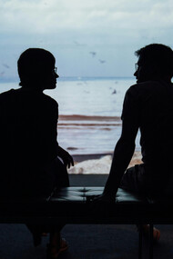A couple reconnecting in front of the ocean