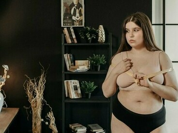 A plus-size woman holding a measuring tape, representing the habit of self-critique in a perfection-driven world