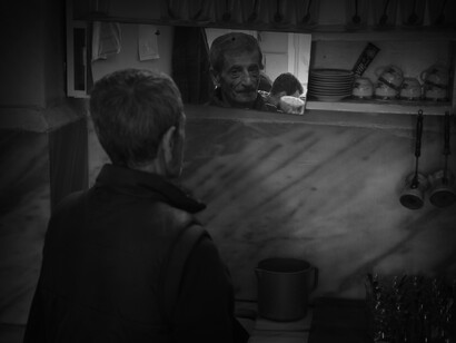 Hombre mayor mira su imagen en el espejo de un bar