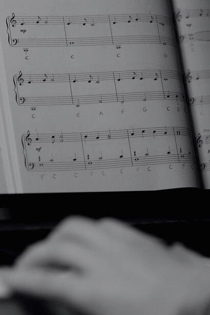 A man playing piano and looking at the musical notes 