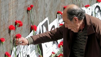 Un hombre deposita una flor ante un altar en recuerdo a los desaparecidos en Chile