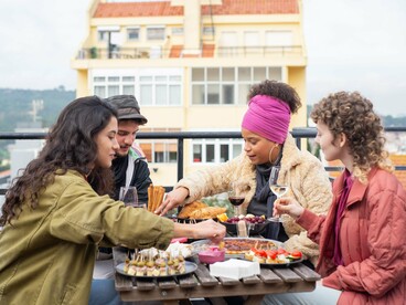 A diverse group connecting over food and conversation, symbolising the growing appeal of community-focused solo travel