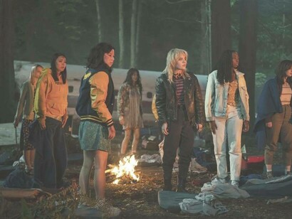 The cast of Yellowjackets alerted by a sound in the woods
