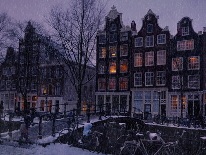 Snow-covered bicycles on a canal street in Amsterdam, Netherlands