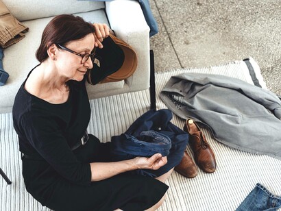 A woman on the floor with the clothes of her lost loved one is grieving mindfully