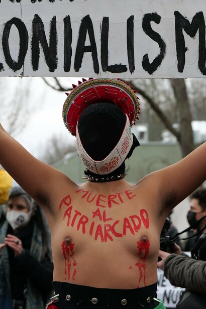 Manifestante sostiene un cartel que dice "Muerte al colonialismo extractivista" durante una marcha en Berlín, Alemania, a raíz de la contaminación producto de la industria petrolera, 2022
