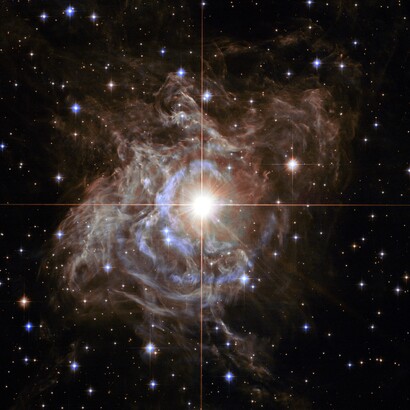 Grazie alla sua attività divulgativa, Hack ha reso l’astronomia accessibile al grande pubblico, unendo rigore scientifico e passione comunicativa. Questa immagine di Hubble mostra "RS Puppis", un tipo di stella variabile nota come variabile Cefeide. Per quanto riguarda le stelle variabili, le Cefeidi hanno periodi relativamente lunghi: RS Puppis, ad esempio, varia la sua luminosità di quasi un fattore cinque ogni 40 giorni circa