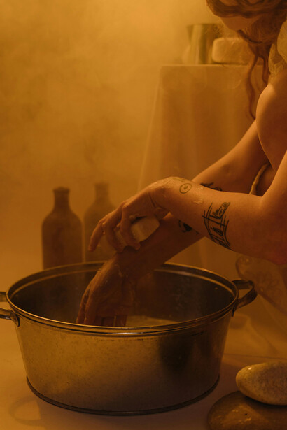 A woman carefully washes her hands in a clean bathroom setting