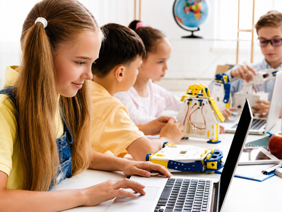 Young students enthusiastically participate in a robotics workshop, proudly showcasing their creations in a bright and innovative classroom