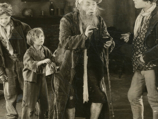 Szene von „Oliver Twist“, Verfilmung aus dem Jahr 1922. Jackie Coogan (zweiter von  Links) verkörpert Oliver Twist im Film