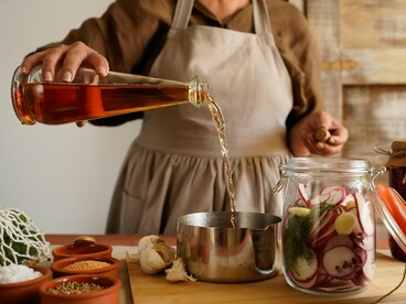 A woman tending to jars of fermenting produce, representing the process of building inner resilience