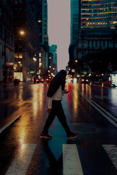 A person walks along the street while using a mobile phone in New York City, United States