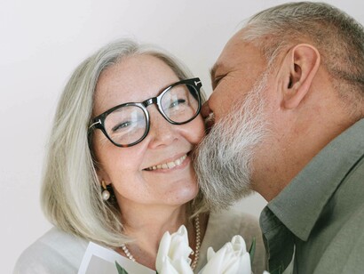 A wife receives flowers and a kiss from her husband