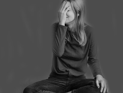 woman covering her face in shame