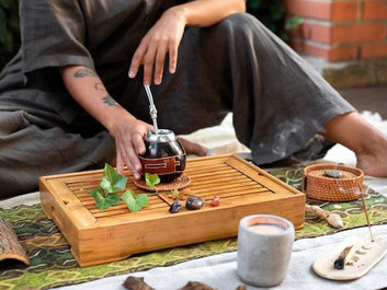 Outdoors, a man holds a cup, symbolizing the integration of Ayurveda, genomics, and personalized medicine with Ayurvedic herbs