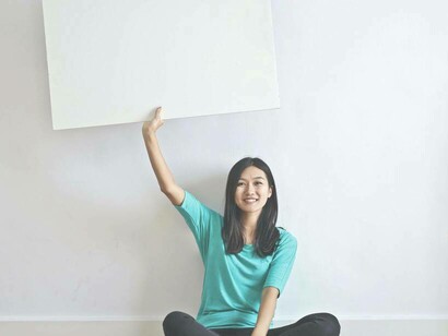 A woman holding up a canvas for a potential validation canvas in her quest to get her idea validated