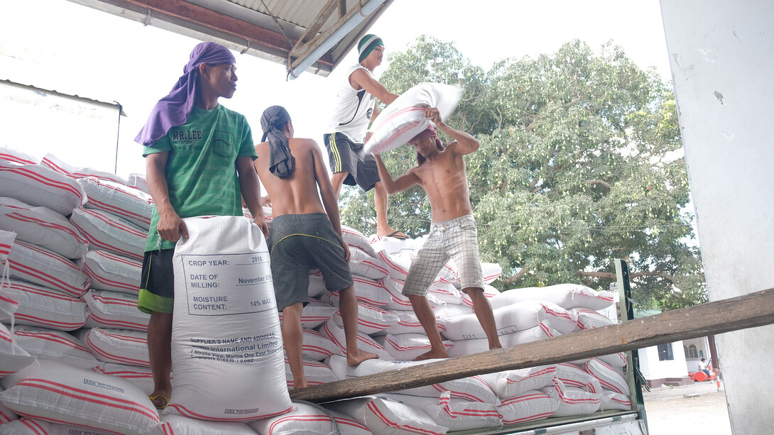 Filipino workers hauling rice bags