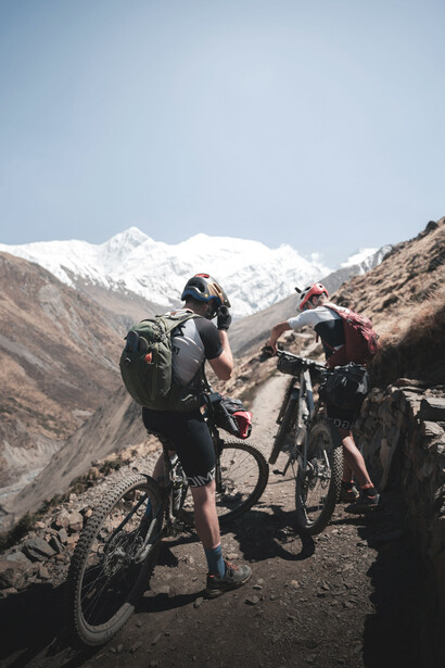 A small group cycling along a scenic dirt road in Nepal