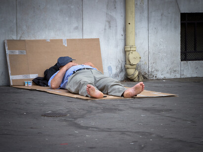 Un hombre durmiendo sobre unos cartones en la calle